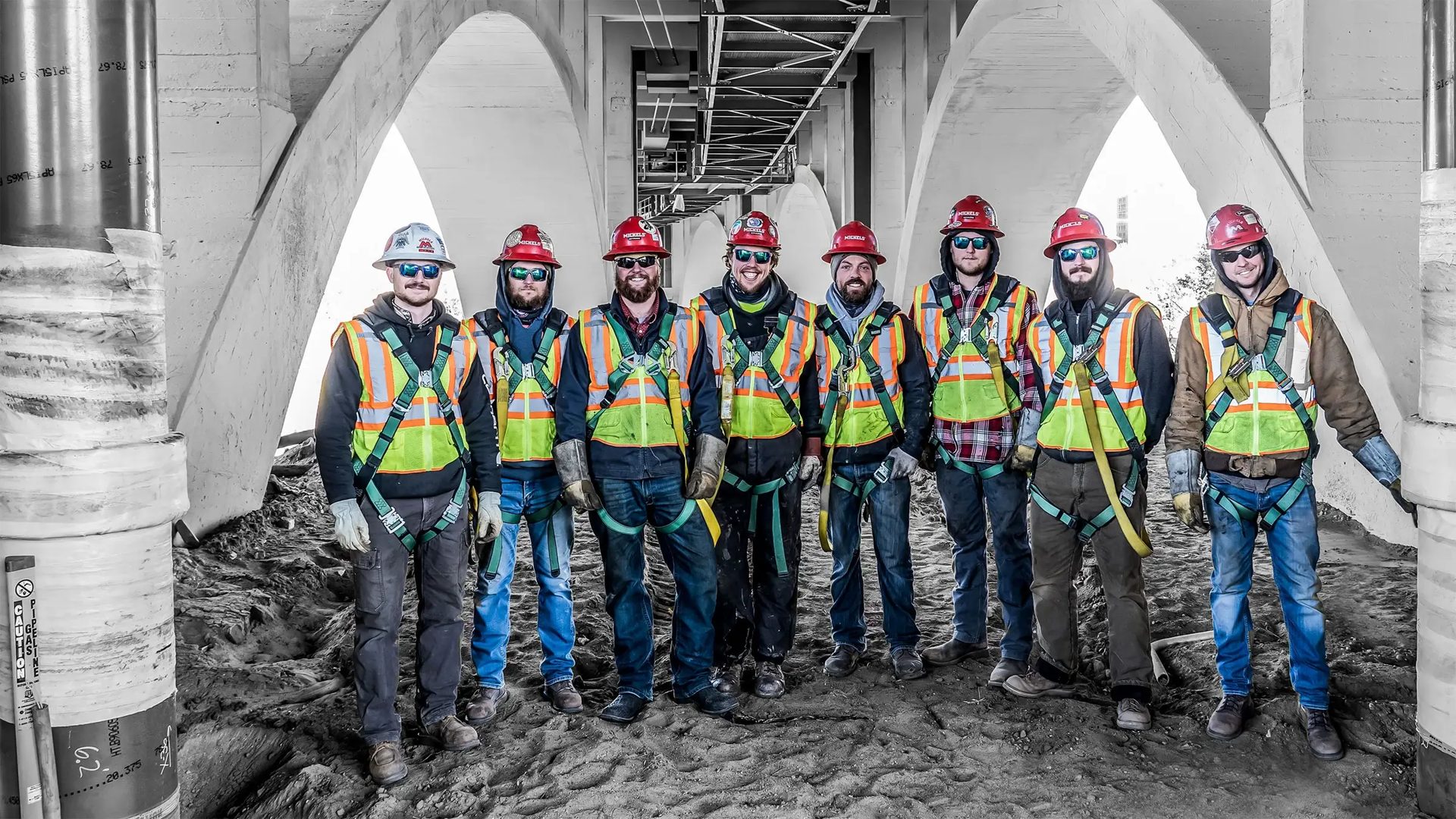 Field crew in safety gear standing together at a job site